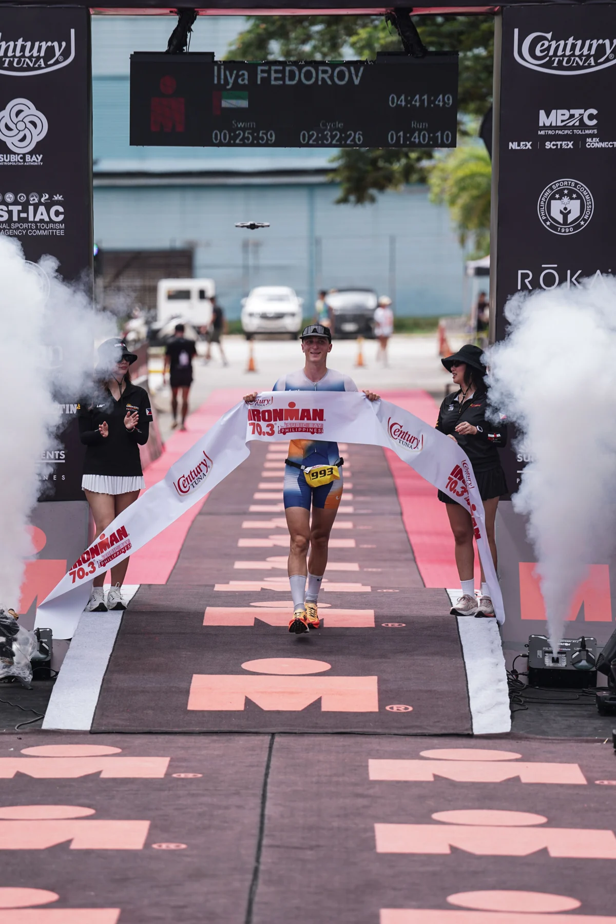 Ilya Fedorov at the Ironman 70.3 Subic Bay finish; the race clock reads 4:41:49